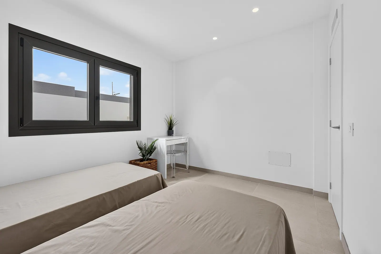 Dormitorio con dos camas y ventana