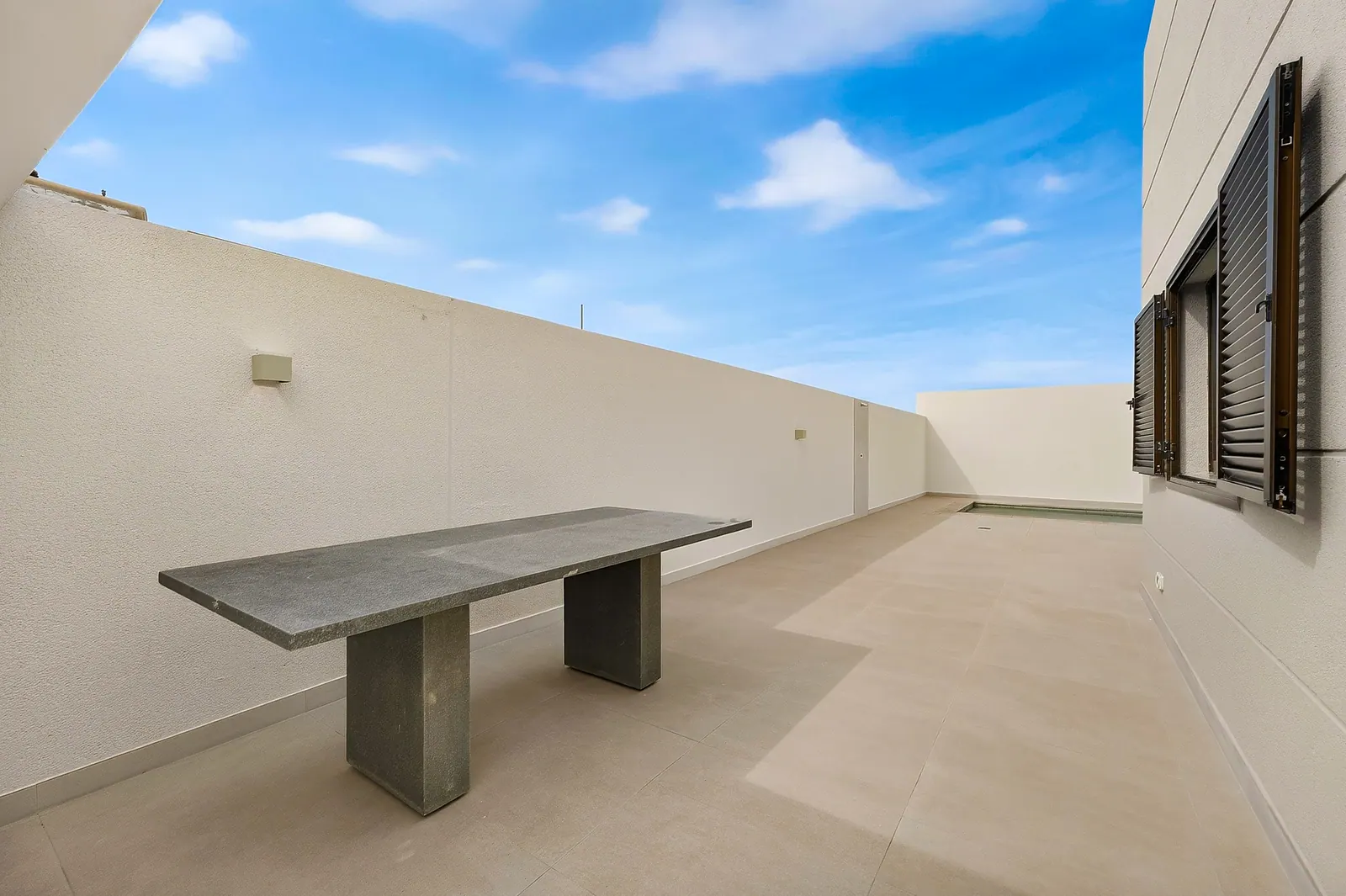 Patio lateral con mesa de piedra