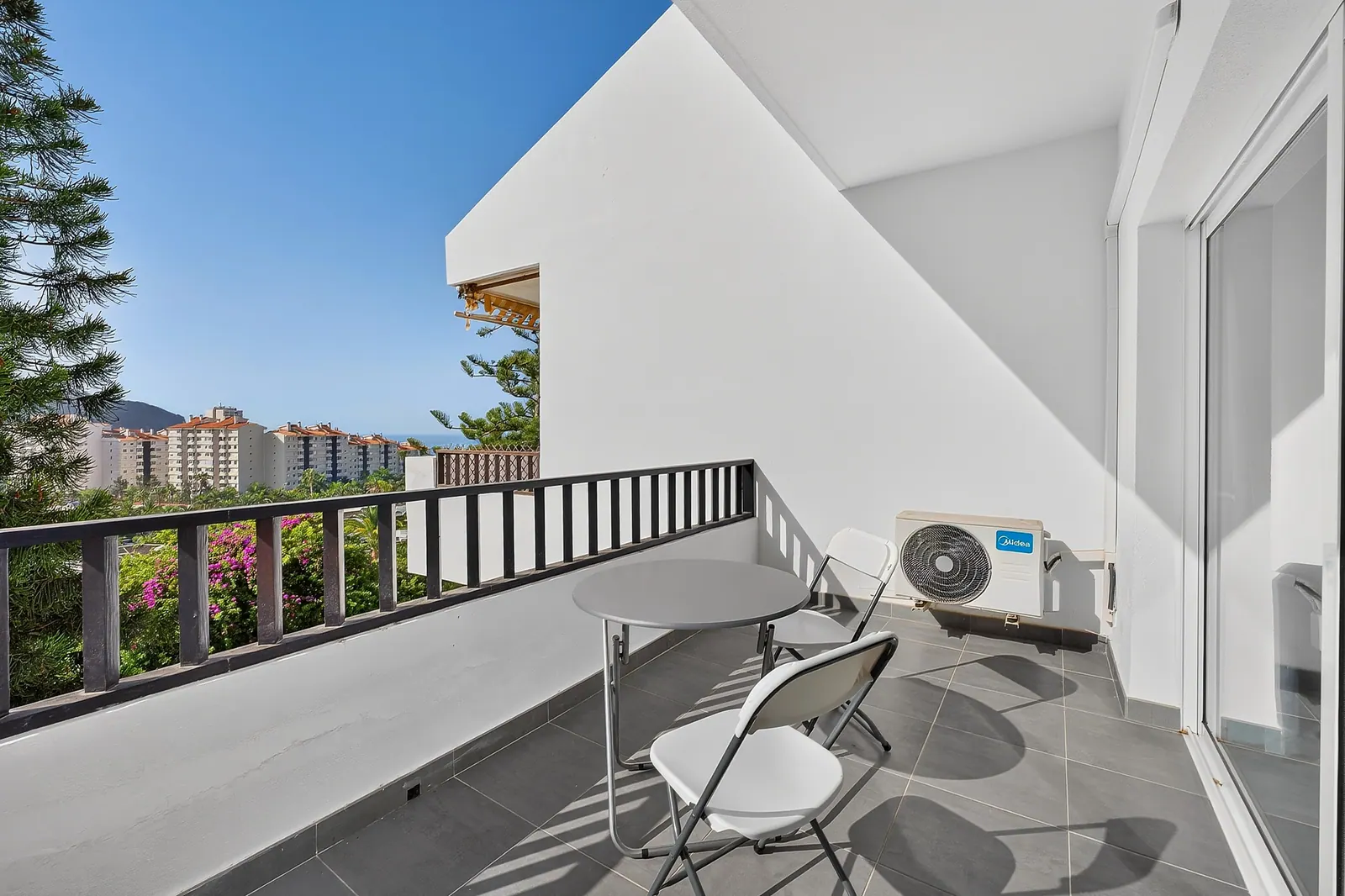 Terraza con mesa y sillas y vistas a la urbanización