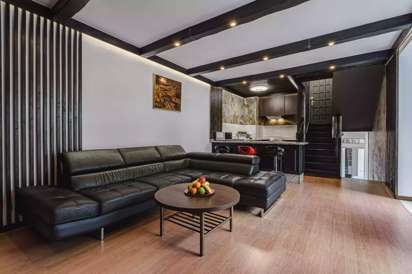 Salón con sofá de cuero y cocina abierta