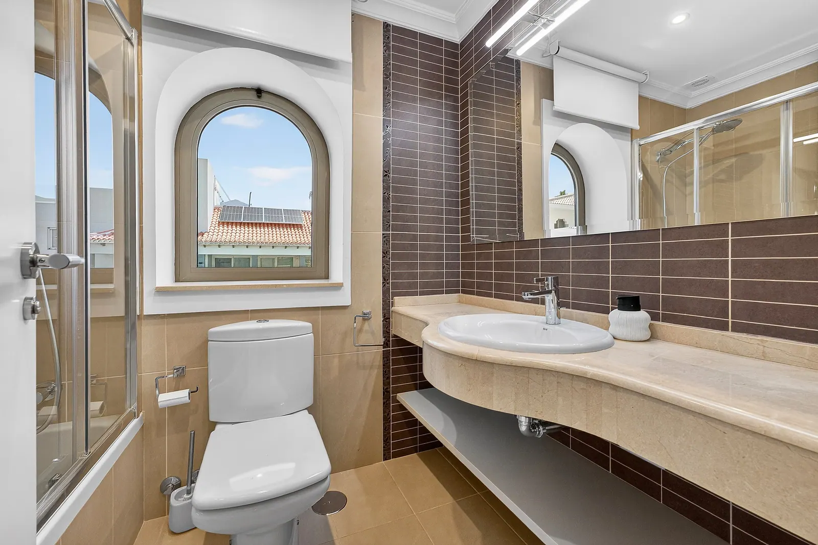 Baño con bañera y ventana en arco