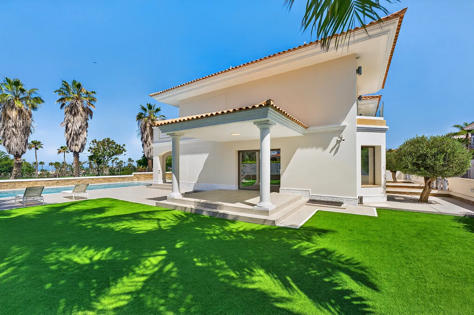 Fachada lateral con jardín de césped