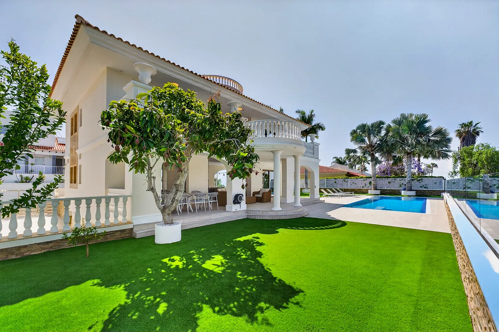 Jardín con césped y porche