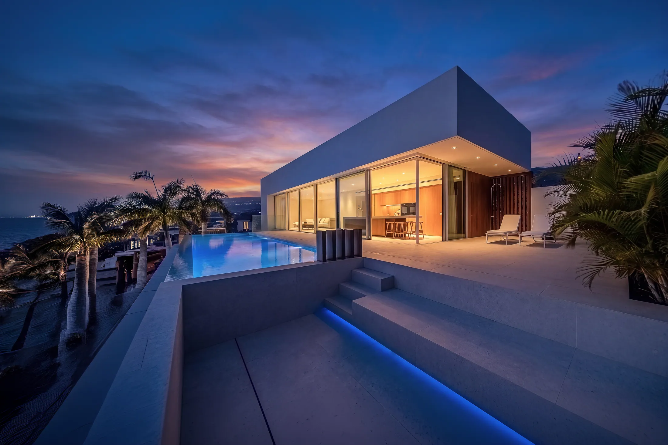 Moderne Villa mit Infinity-Pool in der Abenddämmerung, fotografiert von Fotopisos