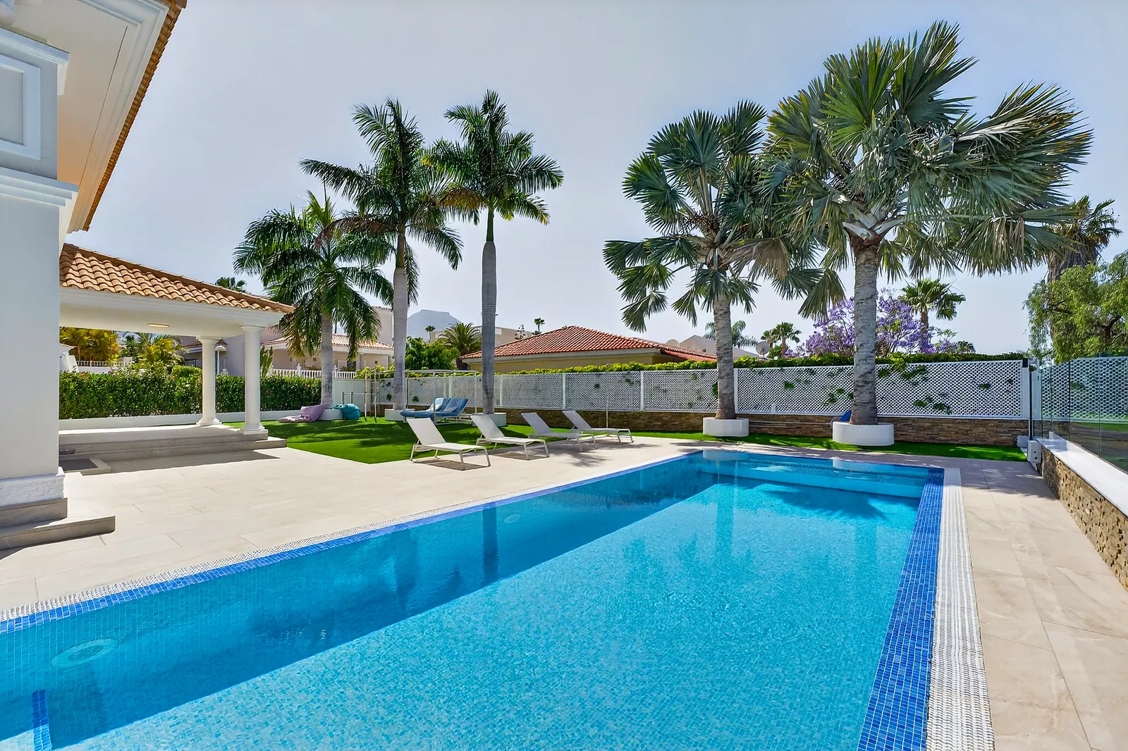 Piscina con palmeras y zona de estar