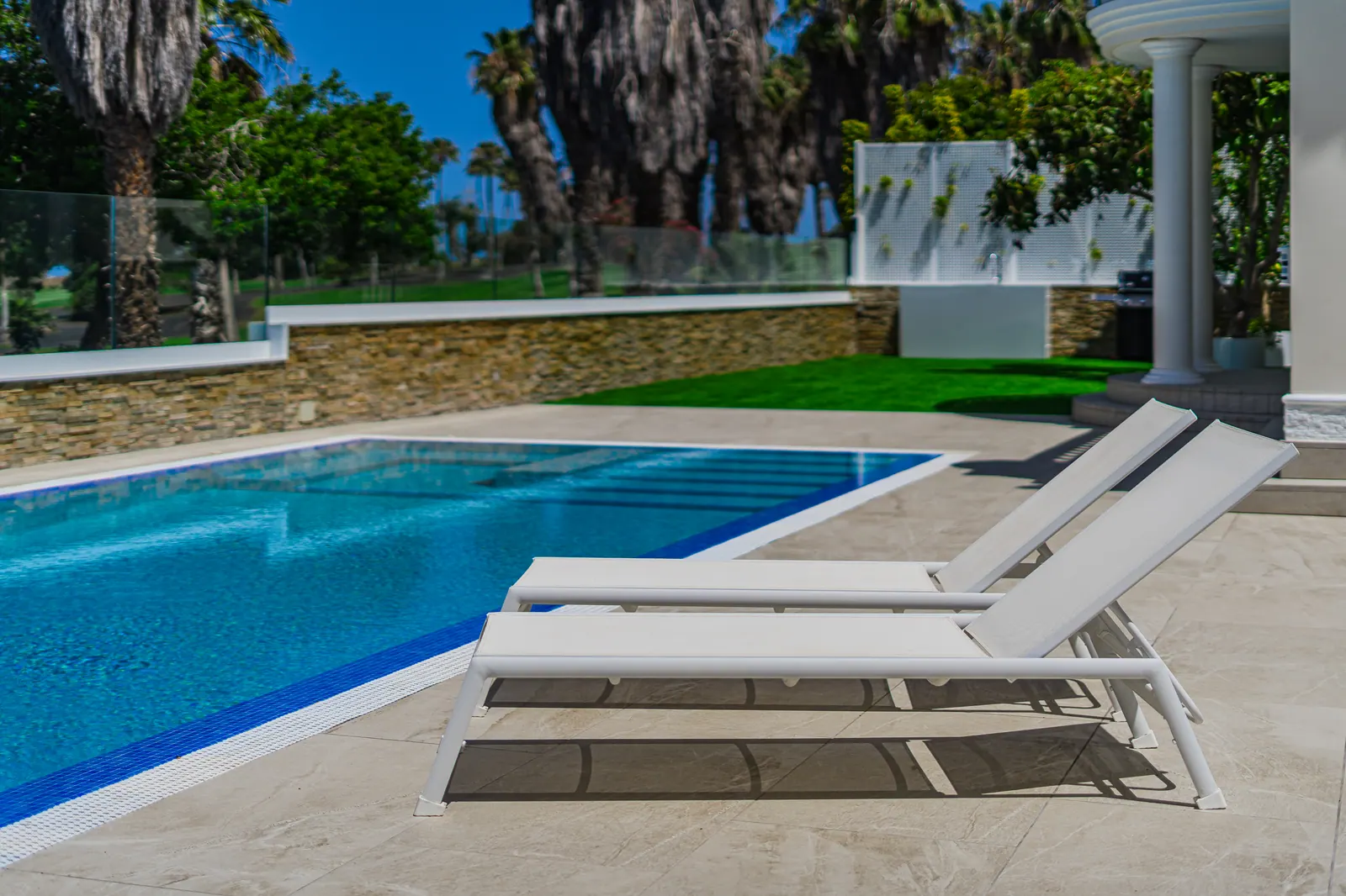 Detalle: tumbonas junto a la piscina