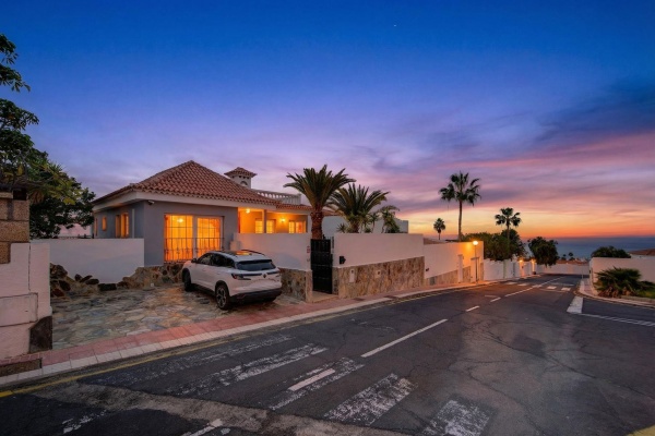 Chalet de lujo con coche blanco en la entrada y espectacular cielo de atardecer editado con Twilight Virtual.